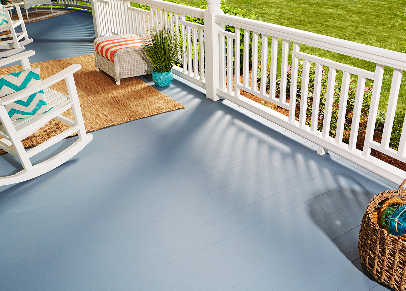 A white rocking chair and porch railing complement a Brookside blue wood exterior floor.